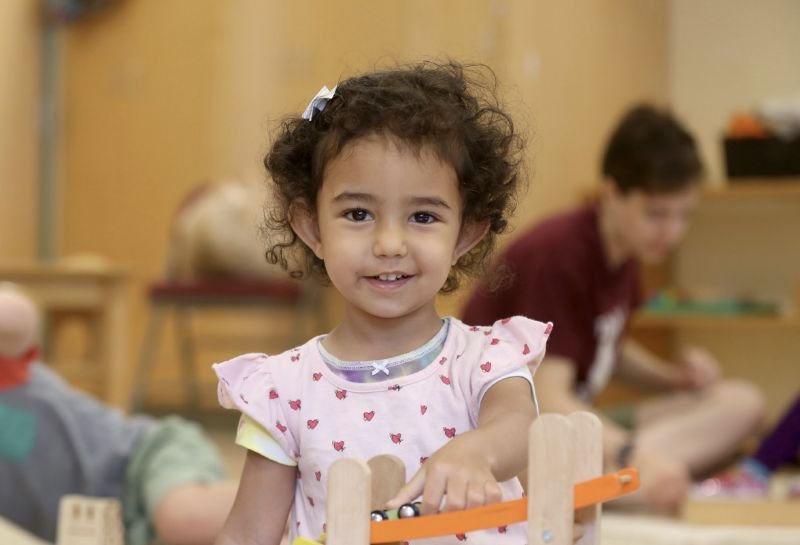 student playing with cars and blocks