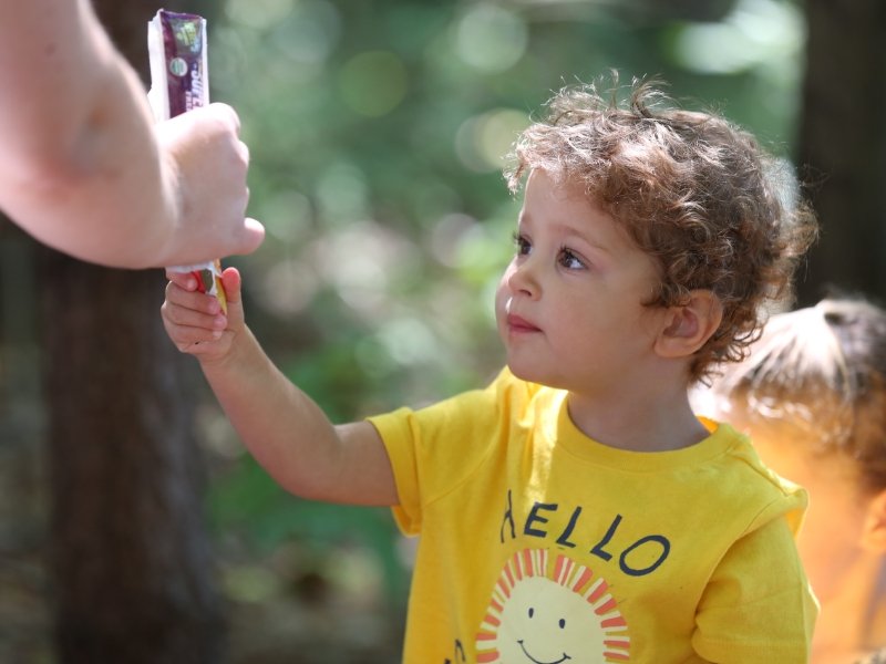 student taking a popsicle from a teacher